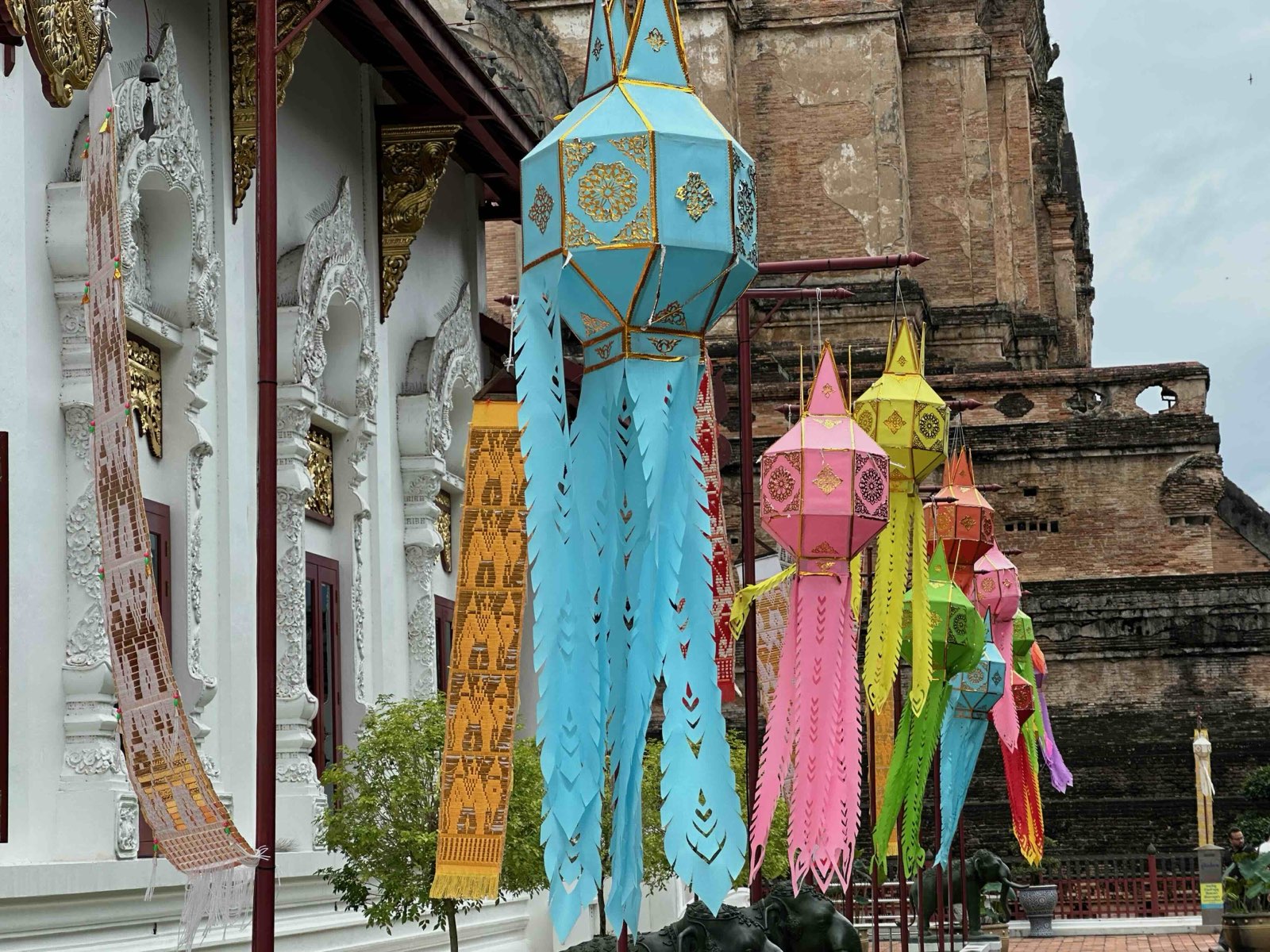 Colourful paper lanterns hanging beside the ruined brick chedi at Wat Chedi Luang in Chiang Mai
